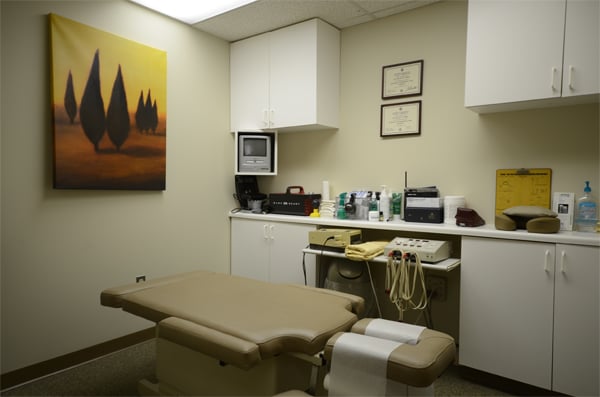 A clean examination room with an exam table and medical equipment