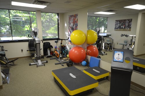 A rehabilitation area with exercise equipment and open floor space